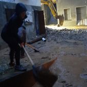 Un residente di Fontainemore al lavoro alle prime ore del mattino per rimuovere i detriti