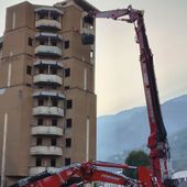 L'enorme braccio d'acciaio di Zeus 'aggredisce' la struttura del palazzone popolare (foto dalla pagina FB del Comune di Aosta)