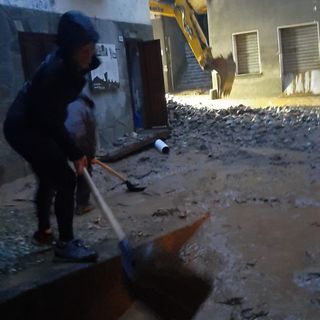 Un residente di Fontainemore al lavoro alle prime ore del mattino per rimuovere i detriti