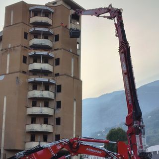 L'enorme braccio d'acciaio di Zeus 'aggredisce' la struttura del palazzone popolare (foto dalla pagina FB del Comune di Aosta)