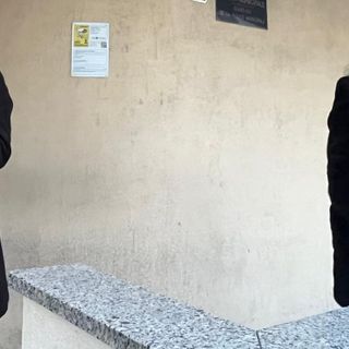 Liliana Padurariu (a dx) insieme a un conoscente con in braccio uno dei due cani all'esterno del Comando della 'Locale'