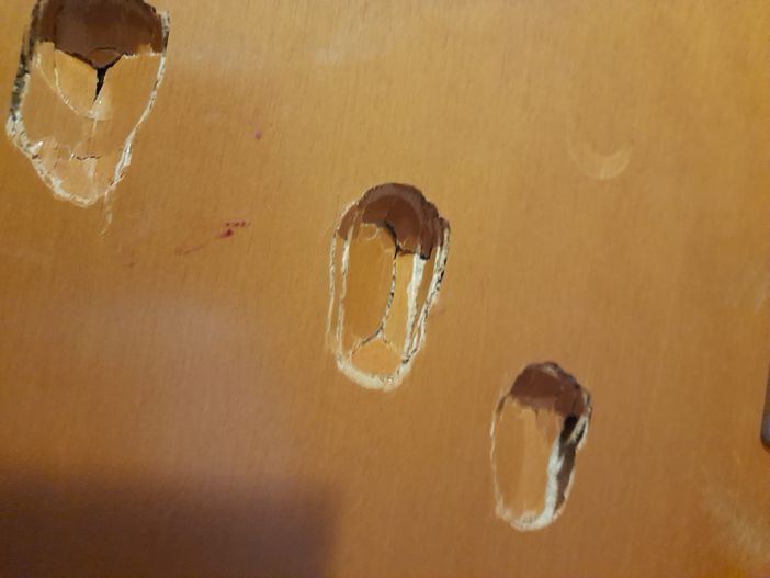I segni delle violente martellate alla porte del condominio I segni delle violente martellate alla porte del condominio