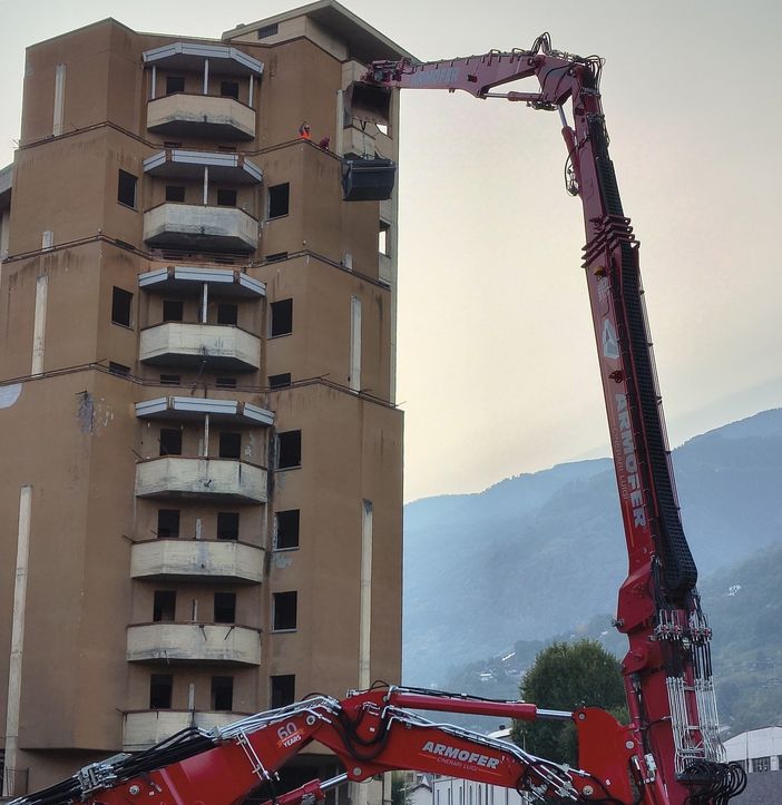 L'enorme braccio d'acciaio di Zeus 'aggredisce' la struttura del palazzone popolare (foto dalla pagina FB del Comune di Aosta)