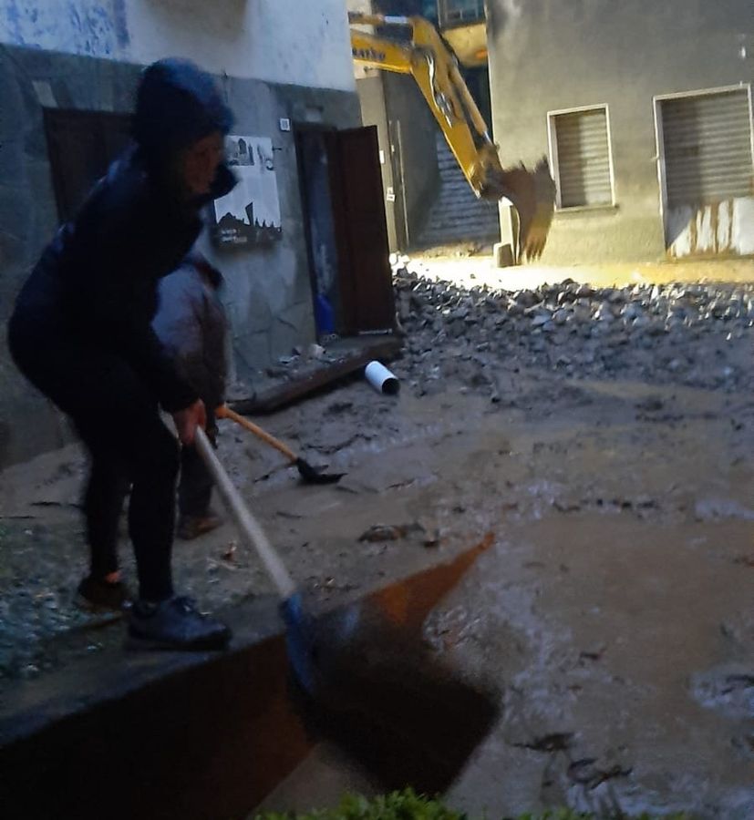 Un residente di Fontainemore al lavoro alle prime ore del mattino per rimuovere i detriti