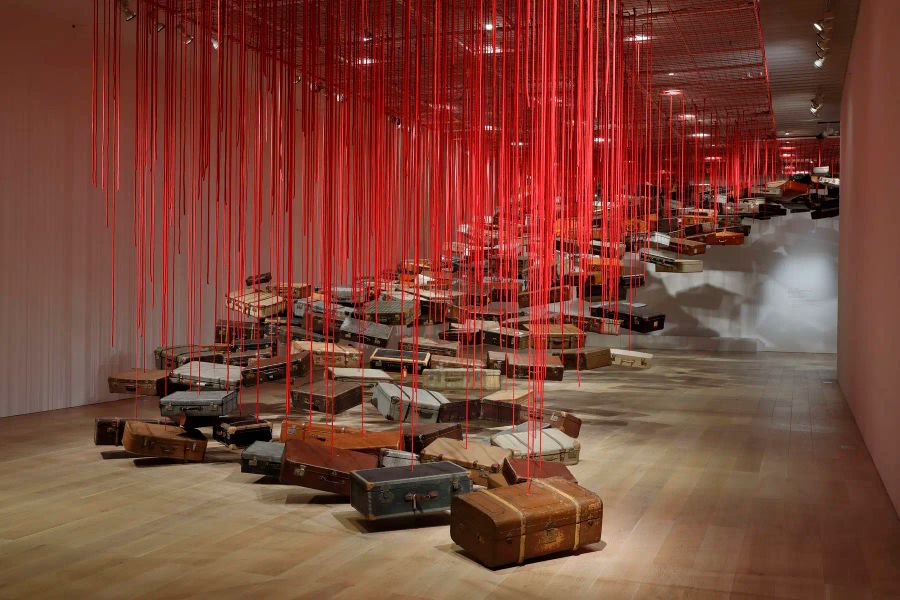 Shiota Chiharu, Accumulation - Searching for the Destination (2014-2019; valigie, motore e corda rossa, dimensioni variabili). Veduta dell’installazione presso la mostra Shiota Chiharu: The Soul Trembles, Mori Art Museum, Tokyo, 2019. Foto: Kioku Keizo. Su concessione di Mori Art Museum, Tokyo