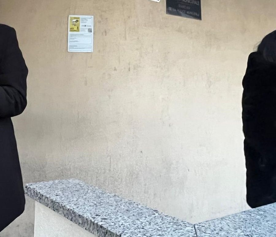 Liliana Padurariu (a dx) insieme a un conoscente con in braccio uno dei due cani all'esterno del Comando della 'Locale'