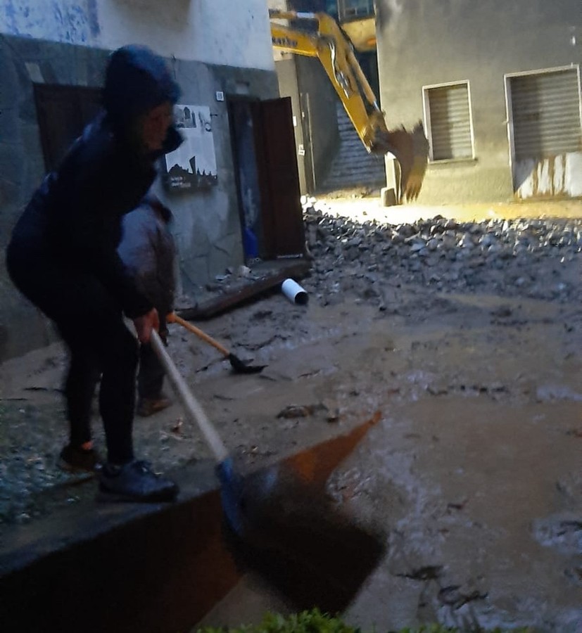 Un residente di Fontainemore al lavoro alle prime ore del mattino per rimuovere i detriti
