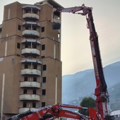 L'enorme braccio d'acciaio di Zeus 'aggredisce' la struttura del palazzone popolare (foto dalla pagina FB del Comune di Aosta)
