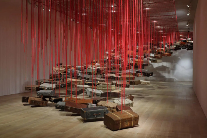 Shiota Chiharu, Accumulation - Searching for the Destination (2014-2019; valigie, motore e corda rossa, dimensioni variabili). Veduta dell’installazione presso la mostra Shiota Chiharu: The Soul Trembles, Mori Art Museum, Tokyo, 2019. Foto: Kioku Keizo. Su concessione di Mori Art Museum, Tokyo Shiota Chiharu, Accumulation - Searching for the Destination (2014-2019; valigie, motore e corda rossa, dimensioni variabili). Veduta dell’installazione presso la mostra Shiota Chiharu: The Soul Trembles, Mori Art Museum, Tokyo, 2019. Foto: Kioku Keizo. Su concessione di Mori Art Museum, Tokyo