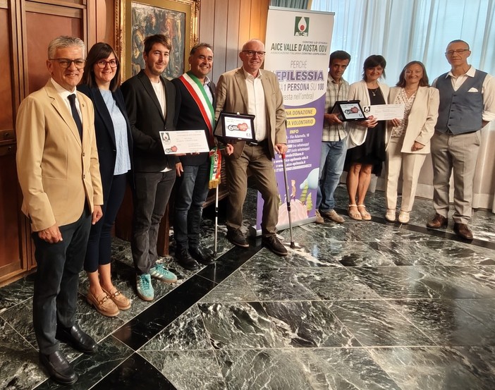 Da sn l'assessore regionale ai Trasporti, Luigi Bertschy; l'assessora al Turismo di Doues, Corinne Cuaz; il vicesindaco di Doues, Daniel Diemoz; il sindaco di Doues, Giorgio Abram; il Presidente della Regione, Renzo Testolin; i genitori della minore di Doues, la Coordinatrice dell’istituzione scolastica Grand Combin, Simona d’Agostino, il Presidente di Aice Valle d’Aosta ODV, Manuele Amateis Da sn l'assessore regionale ai Trasporti, Luigi Bertschy; l'assessora al Turismo di Doues, Corinne Cuaz; il vicesindaco di Doues, Daniel Diemoz; il sindaco di Doues, Giorgio Abram; il Presidente della Regione, Renzo Testolin; i genitori della minore di Doues, la Coordinatrice dell’istituzione scolastica Grand Combin, Simona d’Agostino, il Presidente di Aice Valle d’Aosta ODV, Manuele Amateis