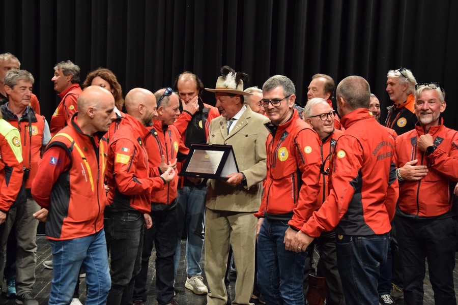 Adriano Favre sul palco del Premio 'circondato' dai colleghi del Soccorso alpino Adriano Favre sul palco del Premio 'circondato' dai colleghi del Soccorso alpino