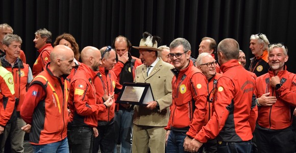Adriano Favre sul palco del Premio 'circondato' dai colleghi del Soccorso alpino Adriano Favre sul palco del Premio 'circondato' dai colleghi del Soccorso alpino
