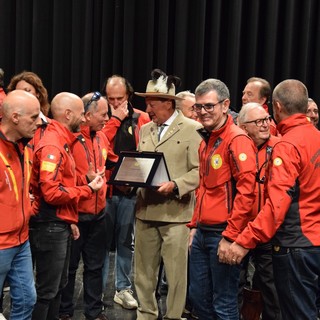 Adriano Favre sul palco del Premio 'circondato' dai colleghi del Soccorso alpino