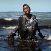 Un ragazzo emerge dalle acque invase dal petrolio davanti alla spiaggia di Itapuama, in Brasile (fotografia di Leo Malafaia)